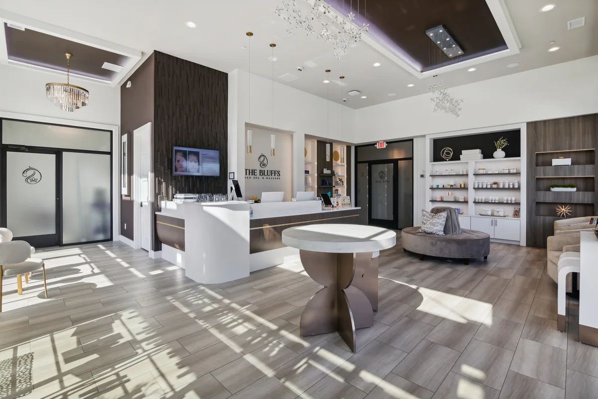 Reception at The Bluffs — charcoal slat wall, curved front desk, and retail shelving