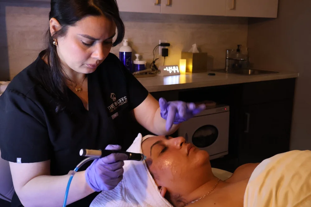 An esthetician at The Bluffs performing a Hydrafacial